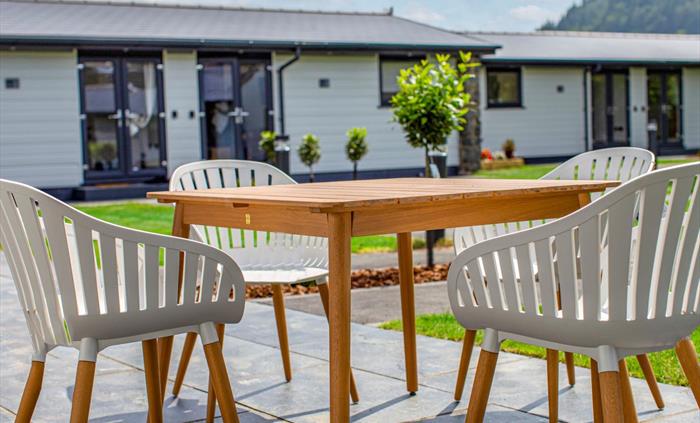 Outdoor dining terrace with lodge, forest and mountain in the background